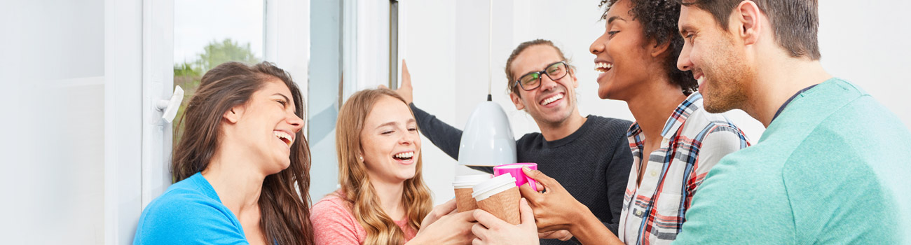 Mitarbeiter:innen eines Unternehmens machen entspannt eine Kaffeepause